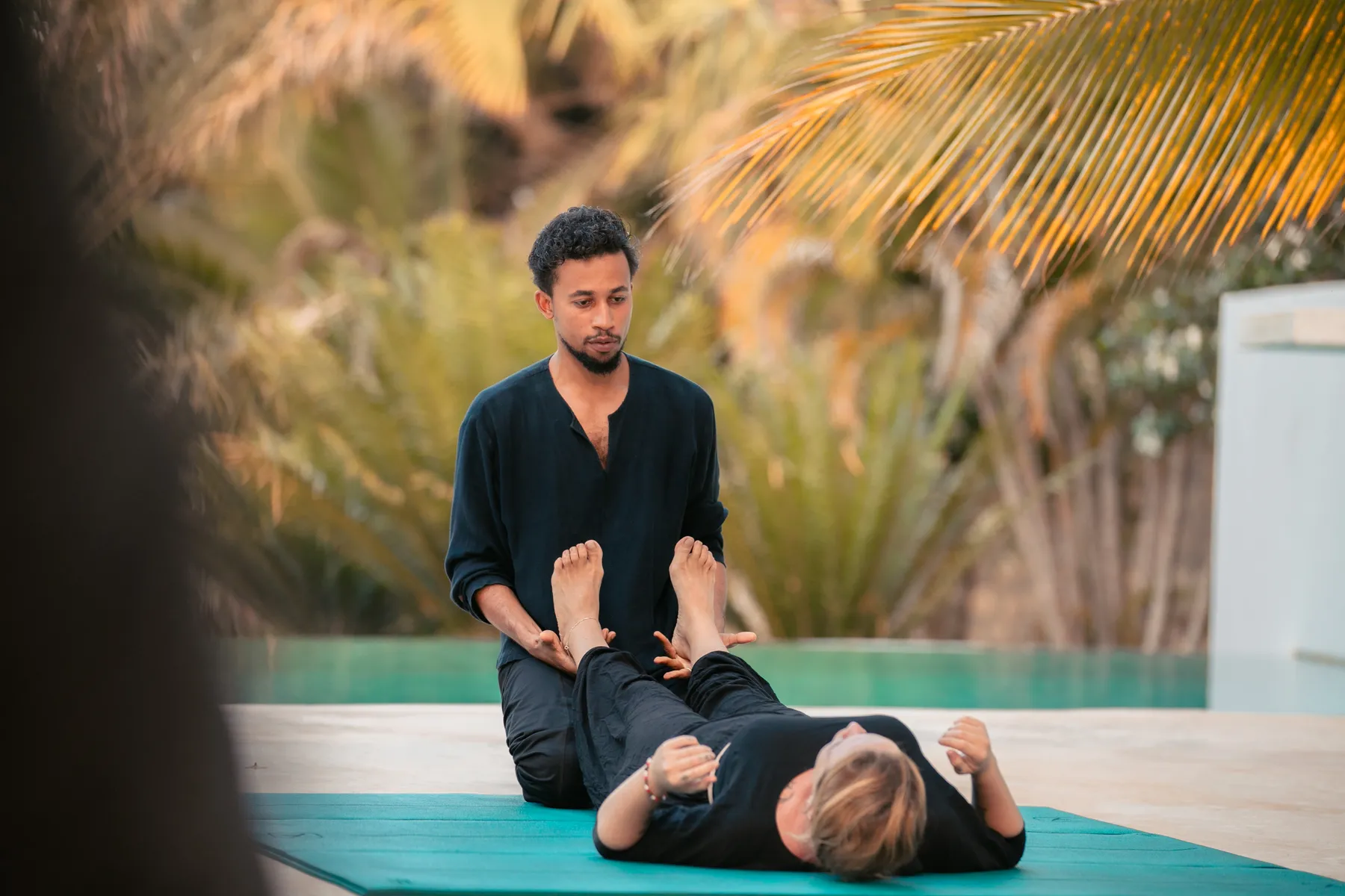 Awham guiding Thaivedic bodywork on a yoga mat