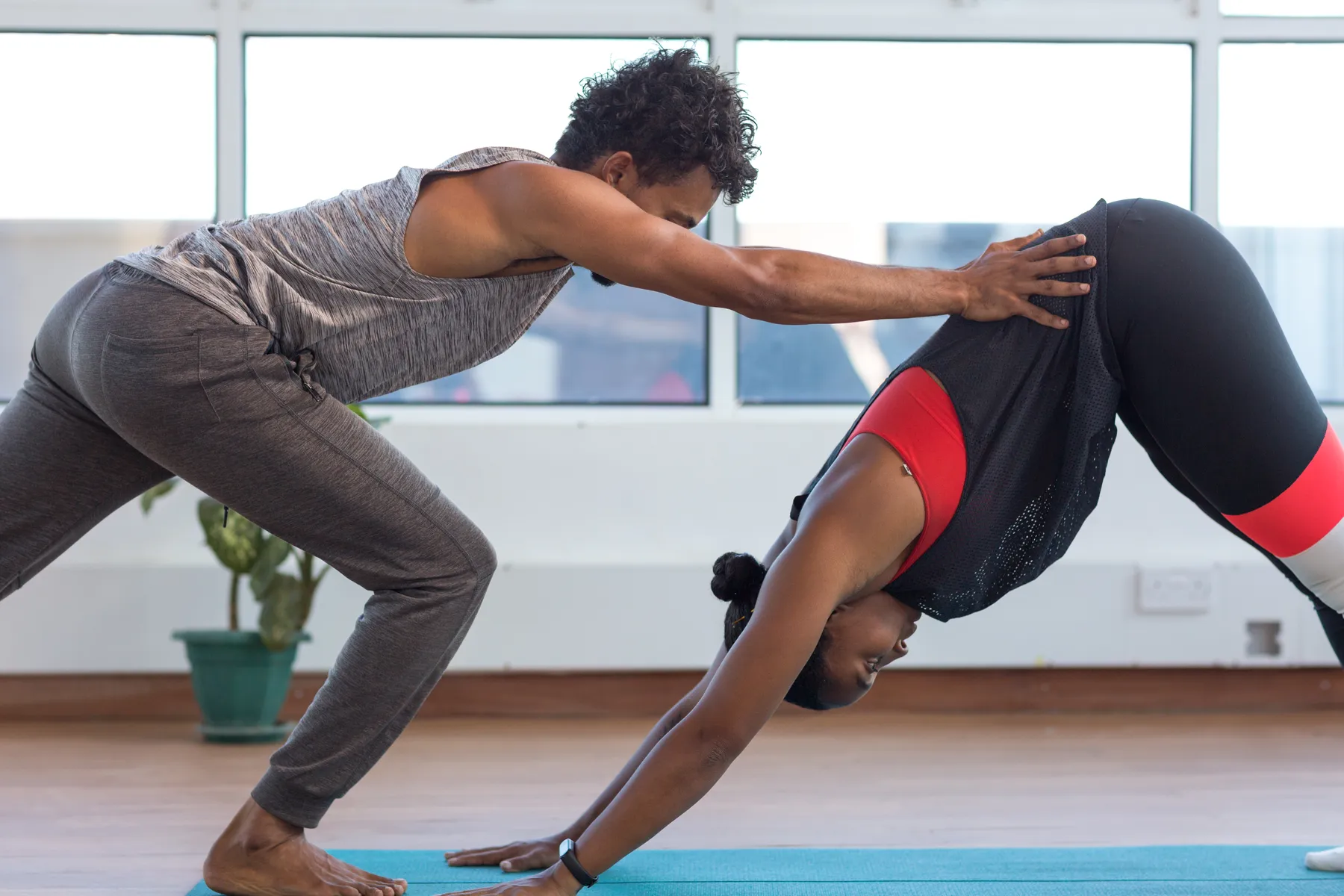 Awham adjusting a student's downward dog in his Lamu studio